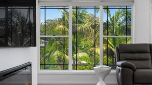 A room with a large window, a fireplace, a modern chair, and a white pedestal. - "Salt & Serenity" – close to Beach & Shops (Terrigal)