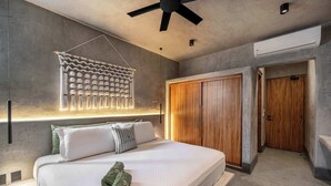 A modern bedroom with a bed, a ceiling fan, a wall-mounted light fixture, and a wardrobe. - Award-Winning Jungle Villa with Rooftop Pool & Bar (Tulum)