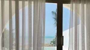 A room with a sliding glass door leading to a beach view. - Le Saint Tropez (Kidoti)