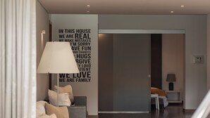 A modern living room with a white sofa, a hammock, and a wall with motivational text.