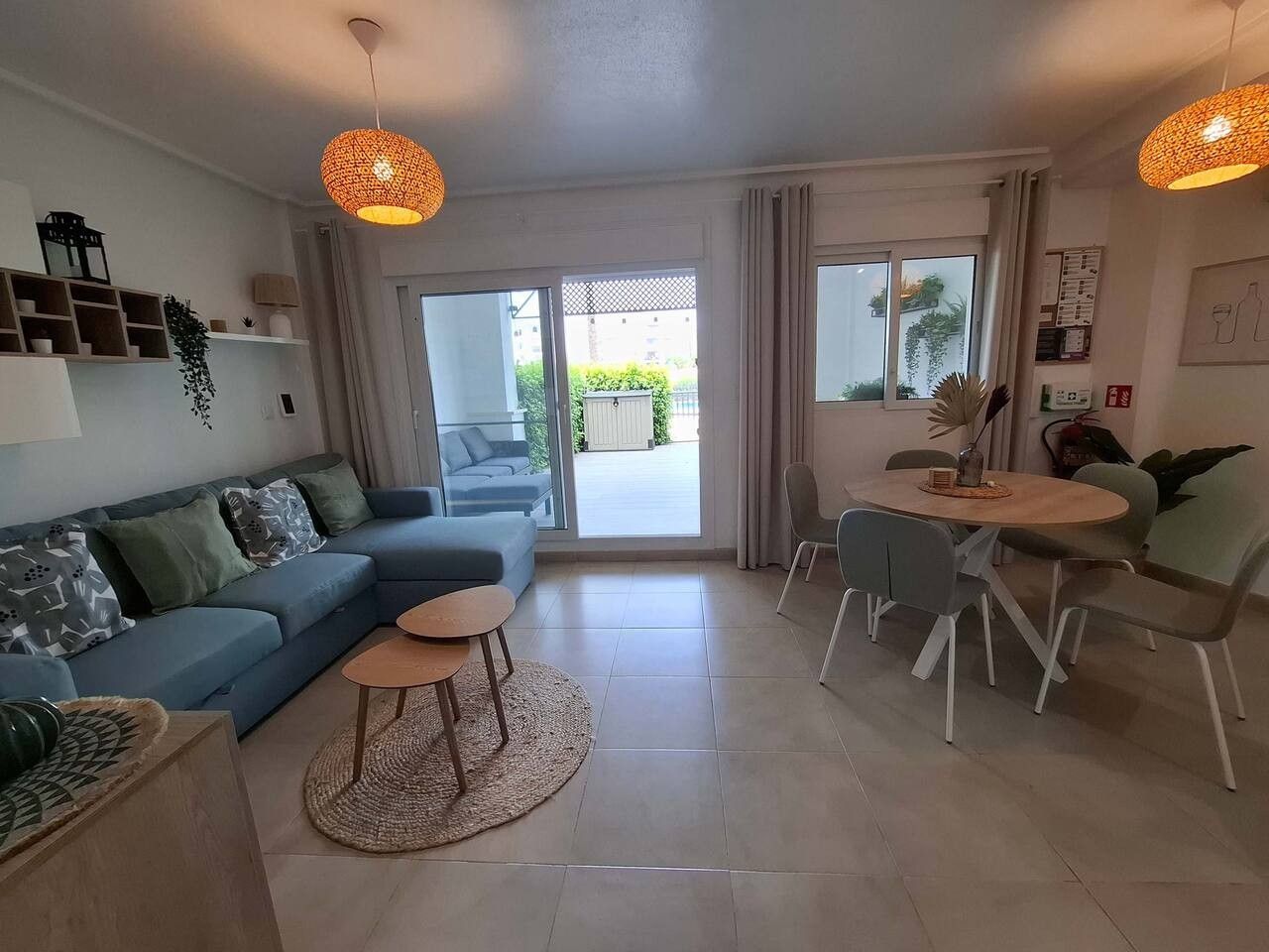 Een moderne woonkamer met een bank, salontafel en een eethoek.