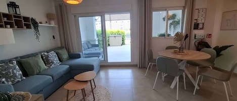 A modern living room with a sofa, coffee table, and dining area.
