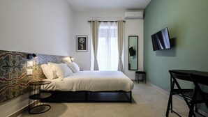 Ein modernes Hotelzimmer mit Bett, Schreibtisch und Fernseher.