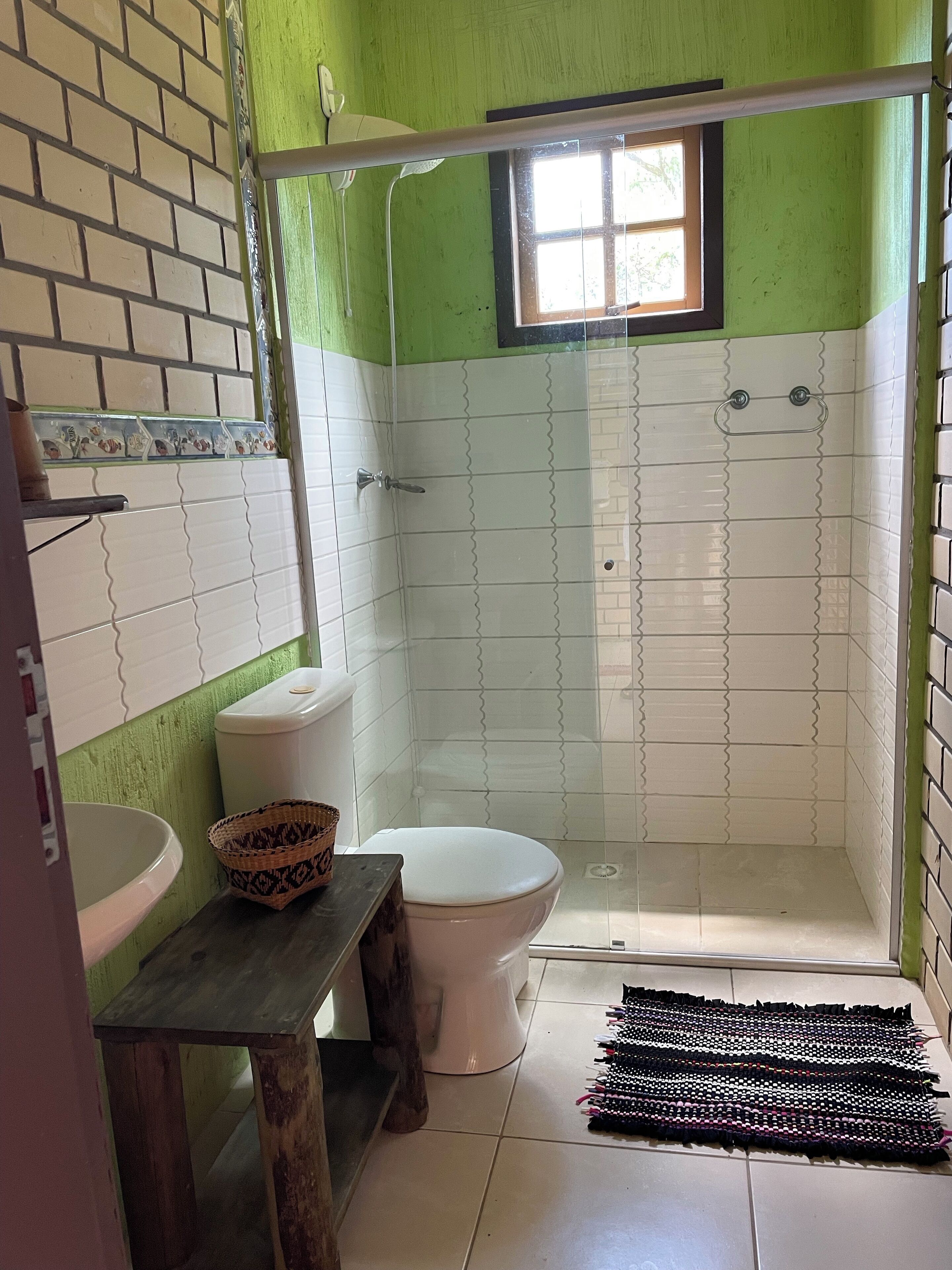 A bathroom with a toilet, sink, and shower area.