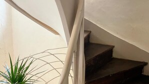 Un escalier avec des rampes blanches et des marches en bois foncé.