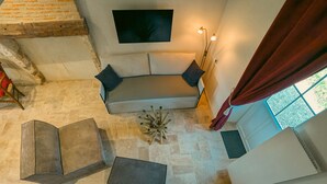 A modern interior with a sofa, a small table, and a staircase. - Charming lodge with parking, pets allowed, near Château de Clavières (Ardentes)