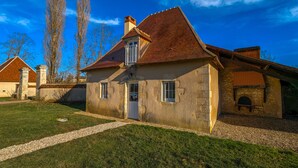 A stone house with a tiled roof, a front door, and a small window. - Charming lodge with parking, pets allowed, near Château de Clavières (Ardentes)