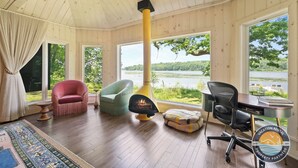 Una habitación acogedora con un ventanal grande, chimenea, escritorio y asientos cómodos.