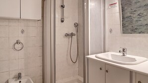 Ein Badezimmer mit Duschkabine, Waschbecken und Toilette.