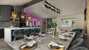 A modern dining area with a marble table, gold accents, and a neon sign. - THE GLAM PALMS (MountainViews/Sauna/EVCharger/BBQ/Golf/HeatedPool) (Palm Springs)