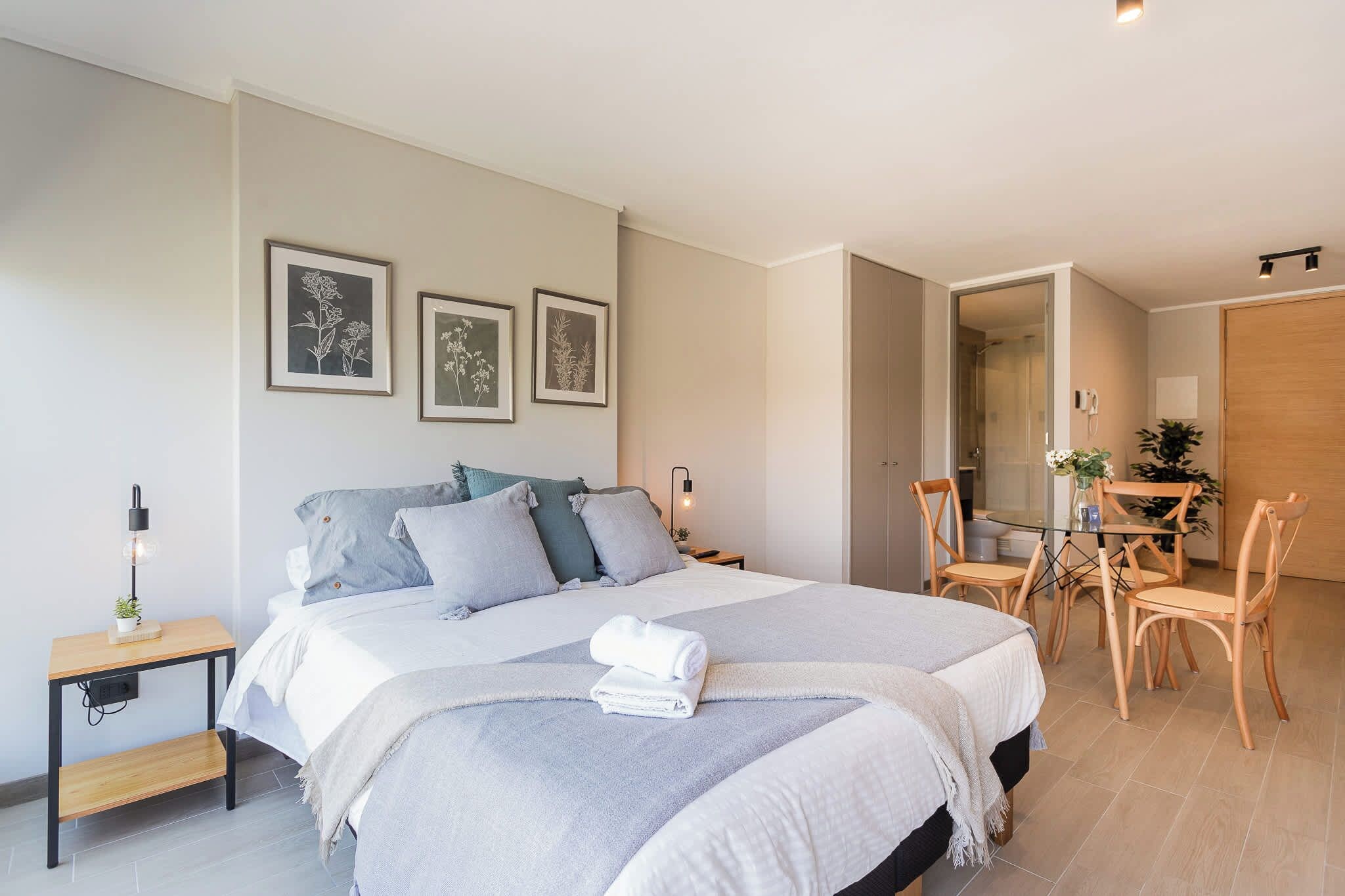 Une chambre à coucher moderne avec un grand lit, des tables de chevet, un bureau et une chaise.