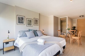 A modern bedroom with a large bed, bedside tables, a desk, and a chair. - Comfortable Studio Apartment in Nunoa Ideal for 2 (Ñuñoa)