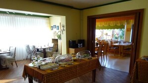 A dining area with a table set for a meal, a television, and a fireplace. - Hotel Miramar  (Dahme)