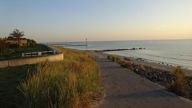 A coastal walkway leading to a beach with a clear sky. - Hotel Miramar  (Dahme)