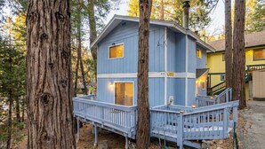 A two-story cabin with a blue exterior, a deck, and a chimney. - ‼️Comfy 2BR Getaway Near Lake Grego w/ Mtn Views (Crestline)