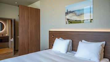 A modern hotel room with a large bed, a wooden headboard, and a cityscape painting on the wall.