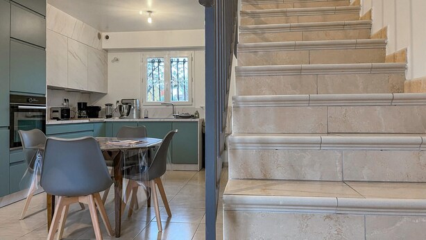 Een moderne keuken met een eethoek, een trap en uitzicht op de omgeving.