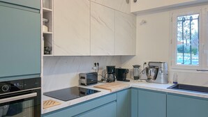 Een moderne keuken met een ingebouwde oven, een koffiezetapparaat en een broodrooster.