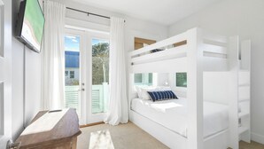 A bedroom with a bunk bed, a television mounted on the wall, and a window with curtains. - ForShore30A - Prominence - Low-speed vehicle,Bunk Room,Large Heated Resort Pool (Panama City Beach)