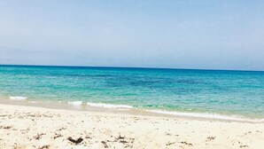 A beach with clear turquoise water and a sandy shore. - Sunset Luxury house, beachfront with beautiful view within walking distance to the beach! (La Ciaccia)