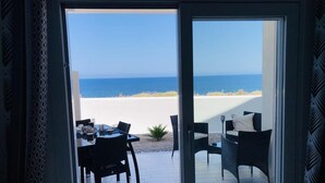 A room with a sliding glass door leading to a patio with a view of the beach. - Sunset Luxury house, beachfront with beautiful view within walking distance to the beach! (La Ciaccia)