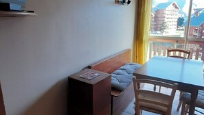 A room with a bed, a TV, a small table, a chair, and a window with curtains. - Studio at the foot of the slopes for 6 people Le Bois d'Aurouze (Dévoluy)