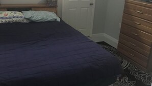 Une chambre à coucher avec un lit, une commode et une porte.