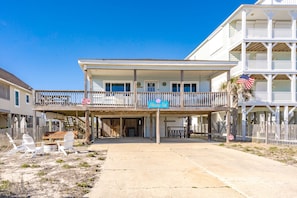Un hôtel situé en bord de mer, doté d’un patio couvert, de sièges extérieurs et d’une enseigne indiquant « Hibiscus Hut ».