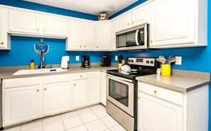 Enjoy cooking and food preparation in this well-equipped kitchen with a stainless steel stove, microwave, coffee maker, and sink.