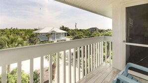Ein Balkon mit Blick auf ein Haus und umliegende Grünflächen.