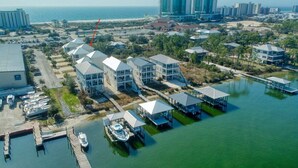 An aerial view of a coastal property with multiple buildings, docks, and a marina. - Flash Sale! Charming home in Orange Beach, AL (Orange Beach)