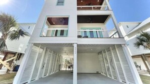 A two-story building with a covered front porch and a balcony on the upper floor. - Flash Sale! Charming home in Orange Beach, AL (Orange Beach)