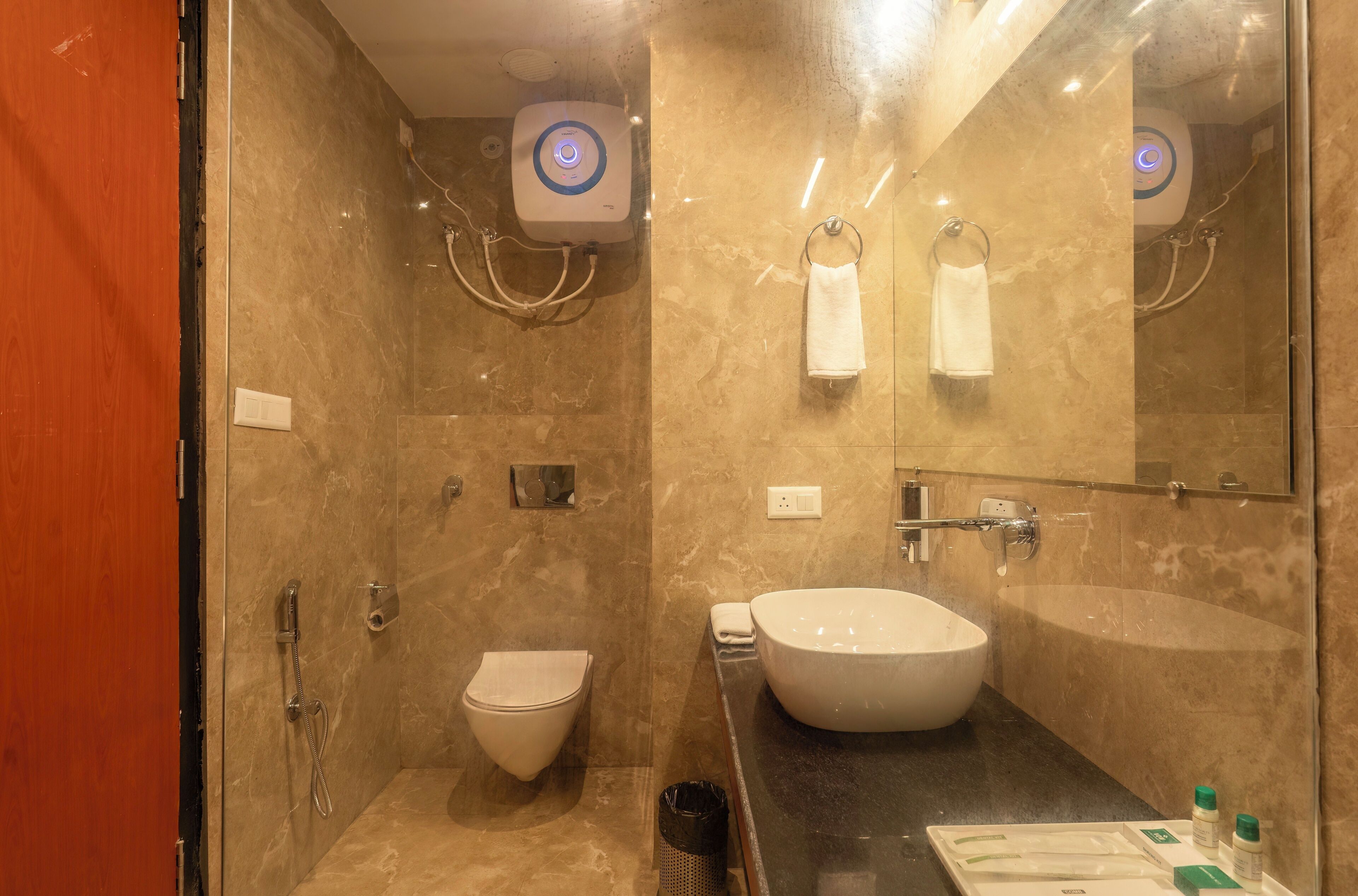 A modern bathroom with a glass-enclosed shower, a white sink, and a toilet.