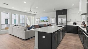 Moderni keittiö, jossa on keskeinen saareke, tummat kaapistot ja suuri ikkuna, josta avautuu näkymä kaupunkimaisemaan.