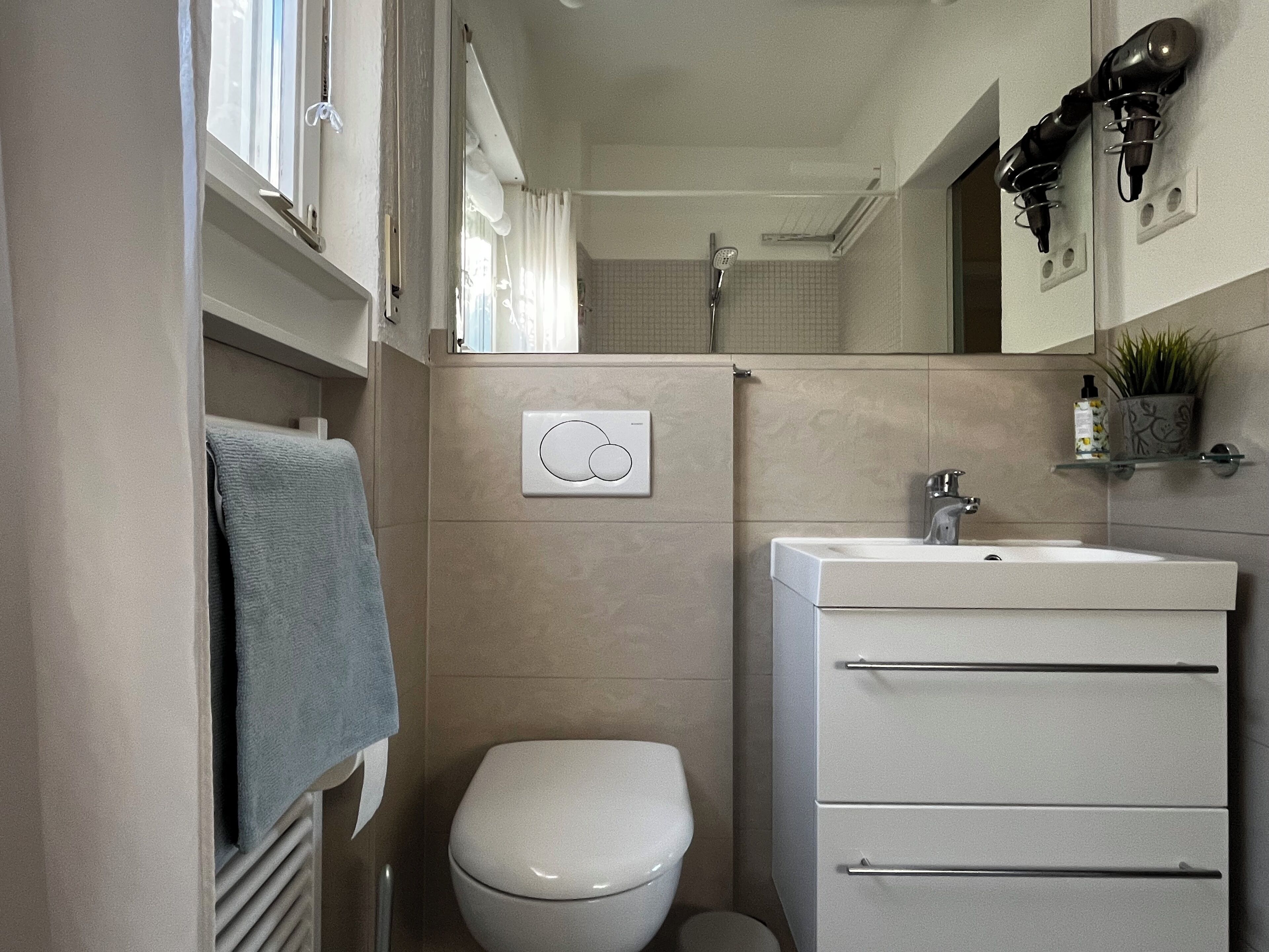 Un baño pequeño con inodoro, lavamanos y ducha.