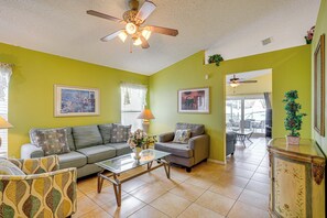 A living room with two sofas, a coffee table, and a ceiling fan.