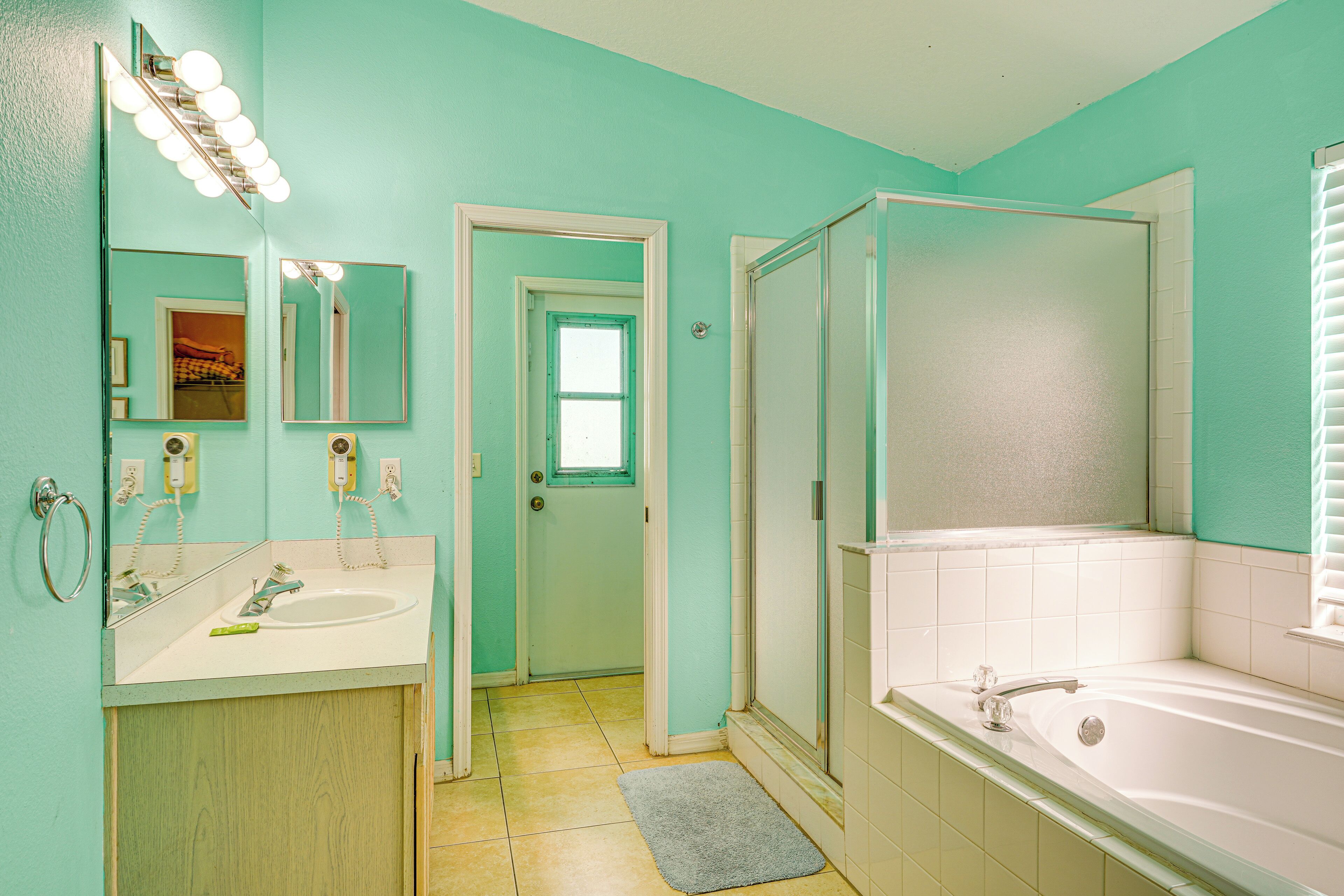 Un baño con lavamanos, espejo y bañera.