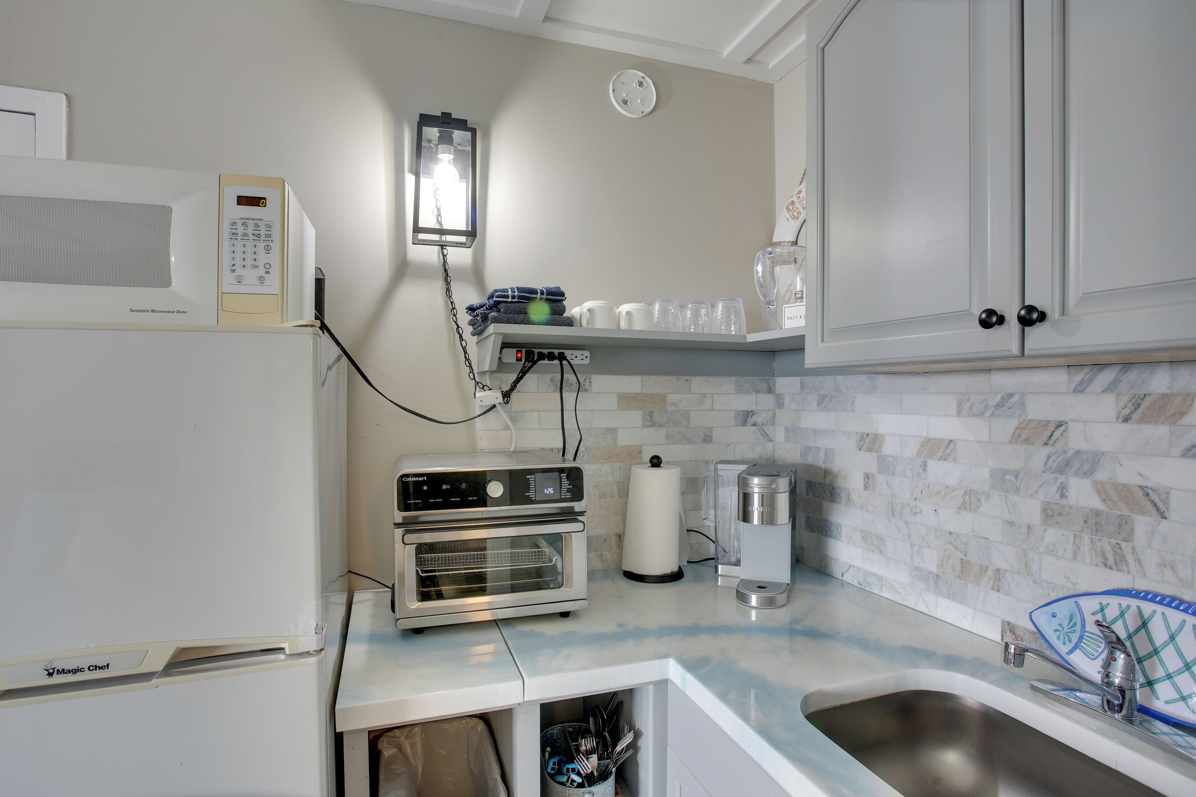 A kitchen with a microwave, toaster oven, and a coffee maker.