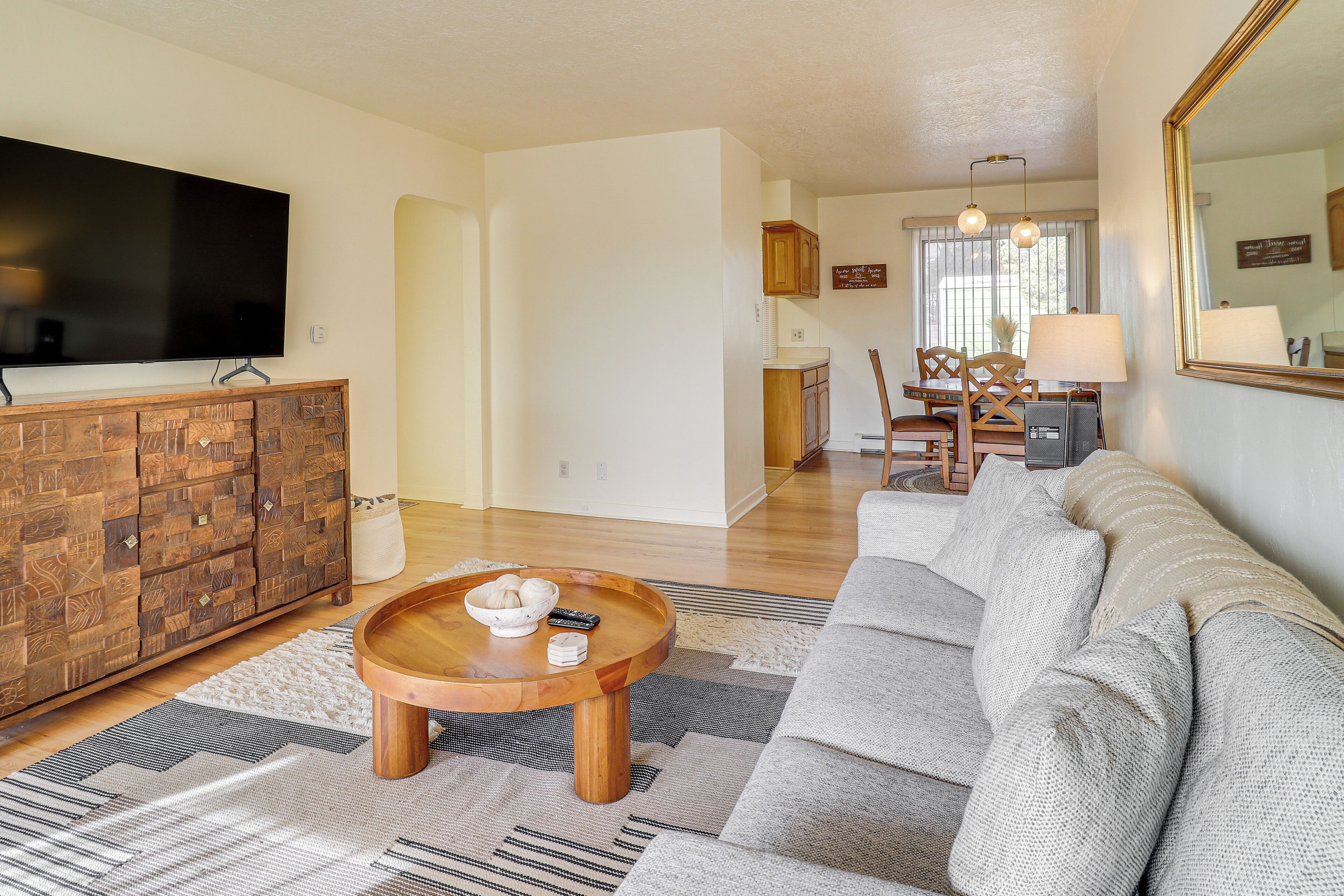 Ein Wohnzimmer mit einer Couch, Couchtisch, Fernseher und Holzschrank.