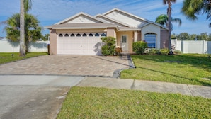 A two-story house with a garage, a driveway, and a well-maintained lawn. - 6 Mi to Disney World: Home w/ Large Yard! (Kissimmee)
