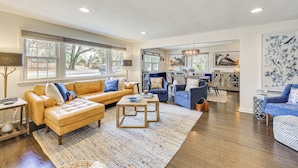 A spacious living room with a large sofa, a coffee table, and a dining area with chairs. - Walk to Powderhouse Polo Fields: Aiken Getaway (Aiken)