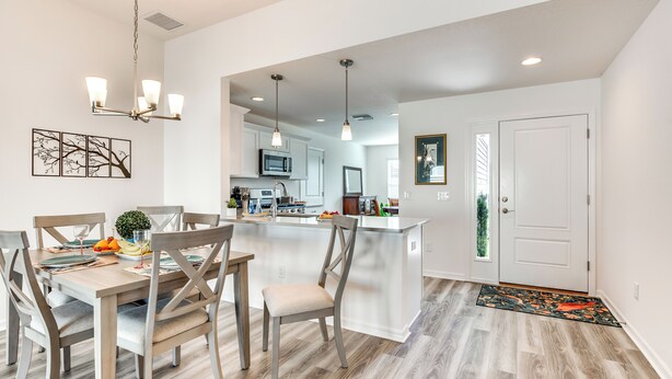 Una cocina moderna con armarios blancos, una isla central e iluminación colgante.