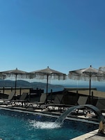 Una piscina techada, una piscina al aire libre de temporada, sombrillas