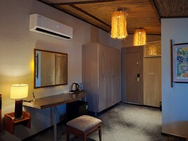 Habitación de hotel con kitchenette, espejo, ventilador de techo y puerta.
