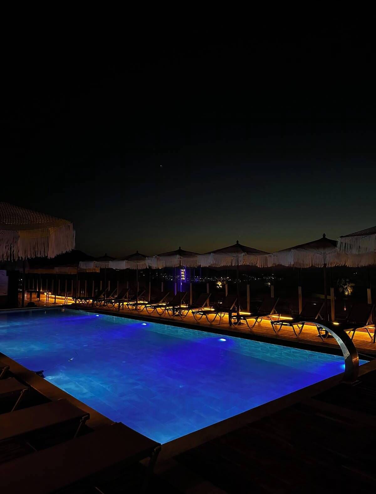Una piscina techada, una piscina al aire libre de temporada, sombrillas