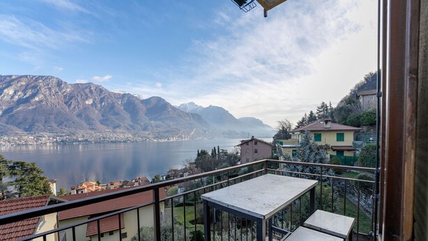 A balcony with a view of a lake and mountains.