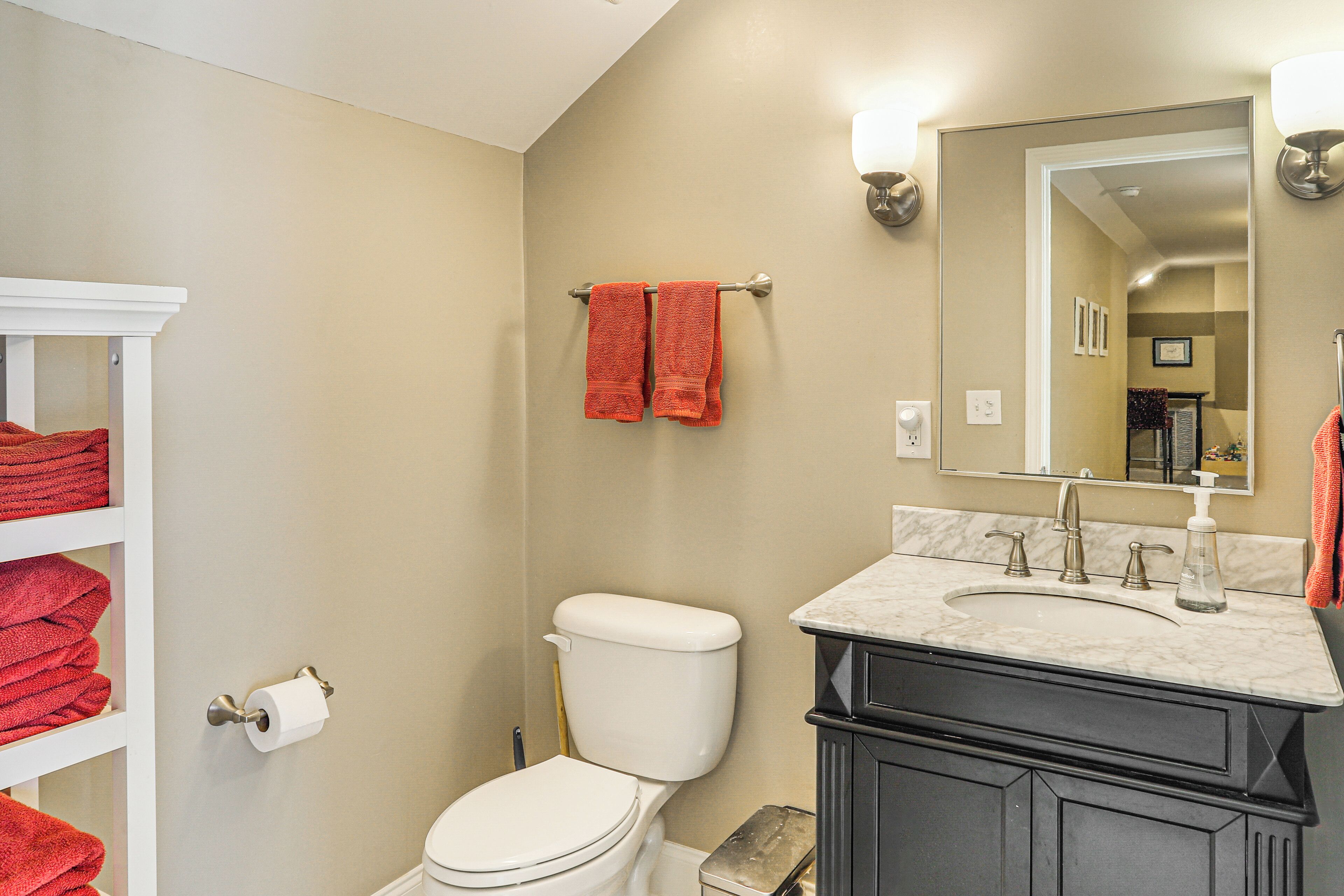 A bathroom with a toilet, sink, and towel rack.