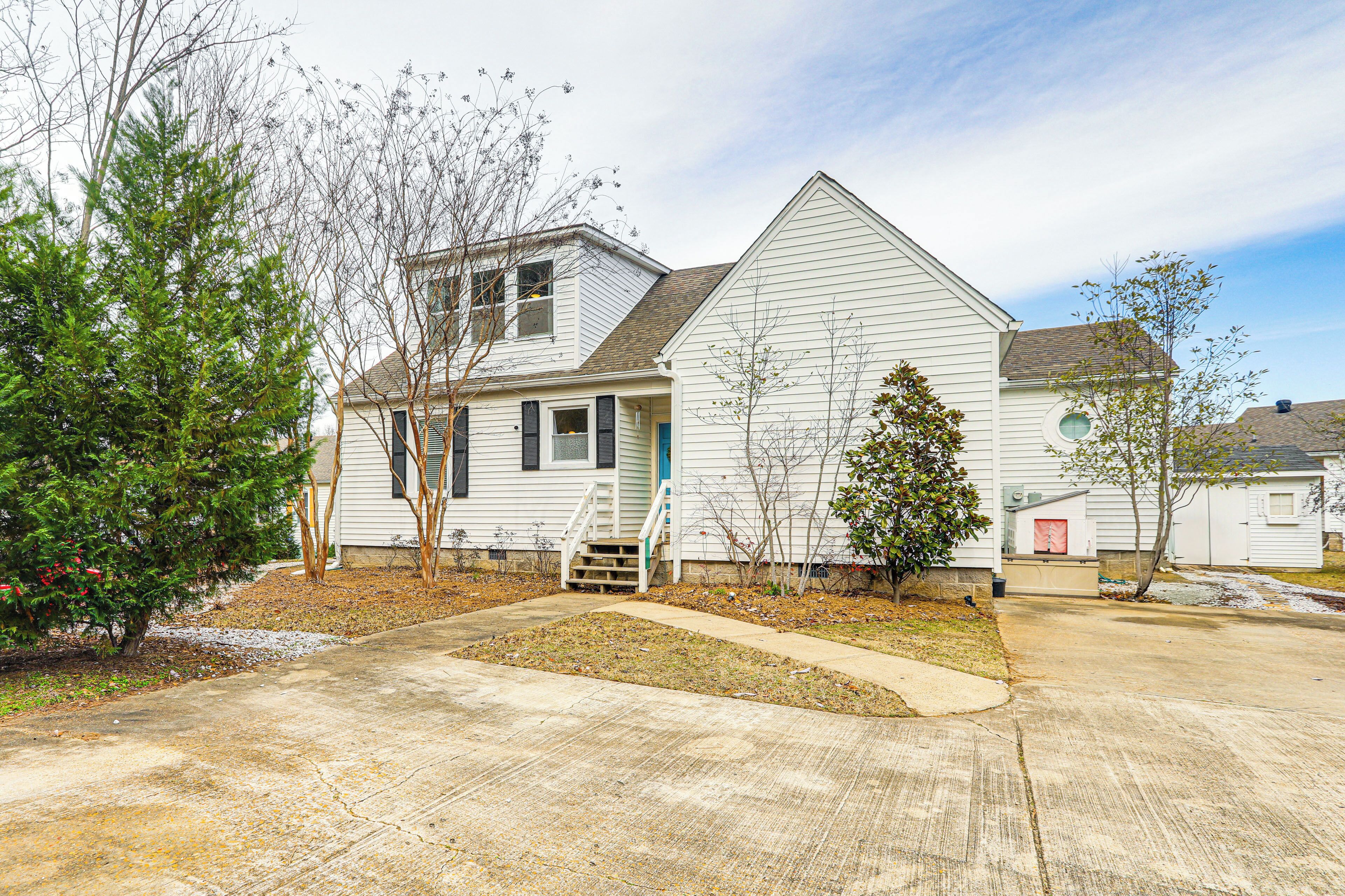 A two-story house with a front porch, a small front yard, and a driveway.