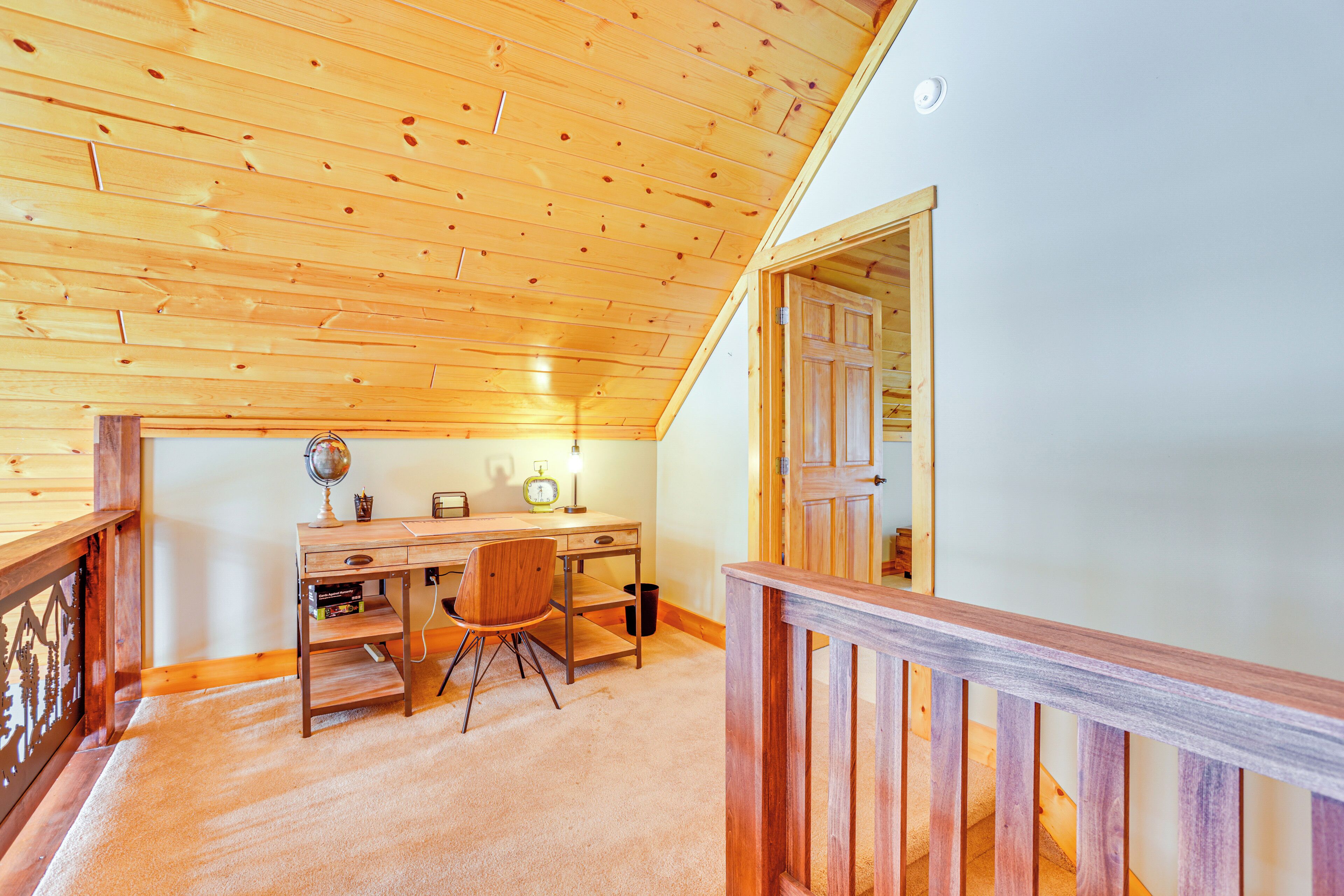 Un interior de madera con un escritorio, una silla y una escalera.