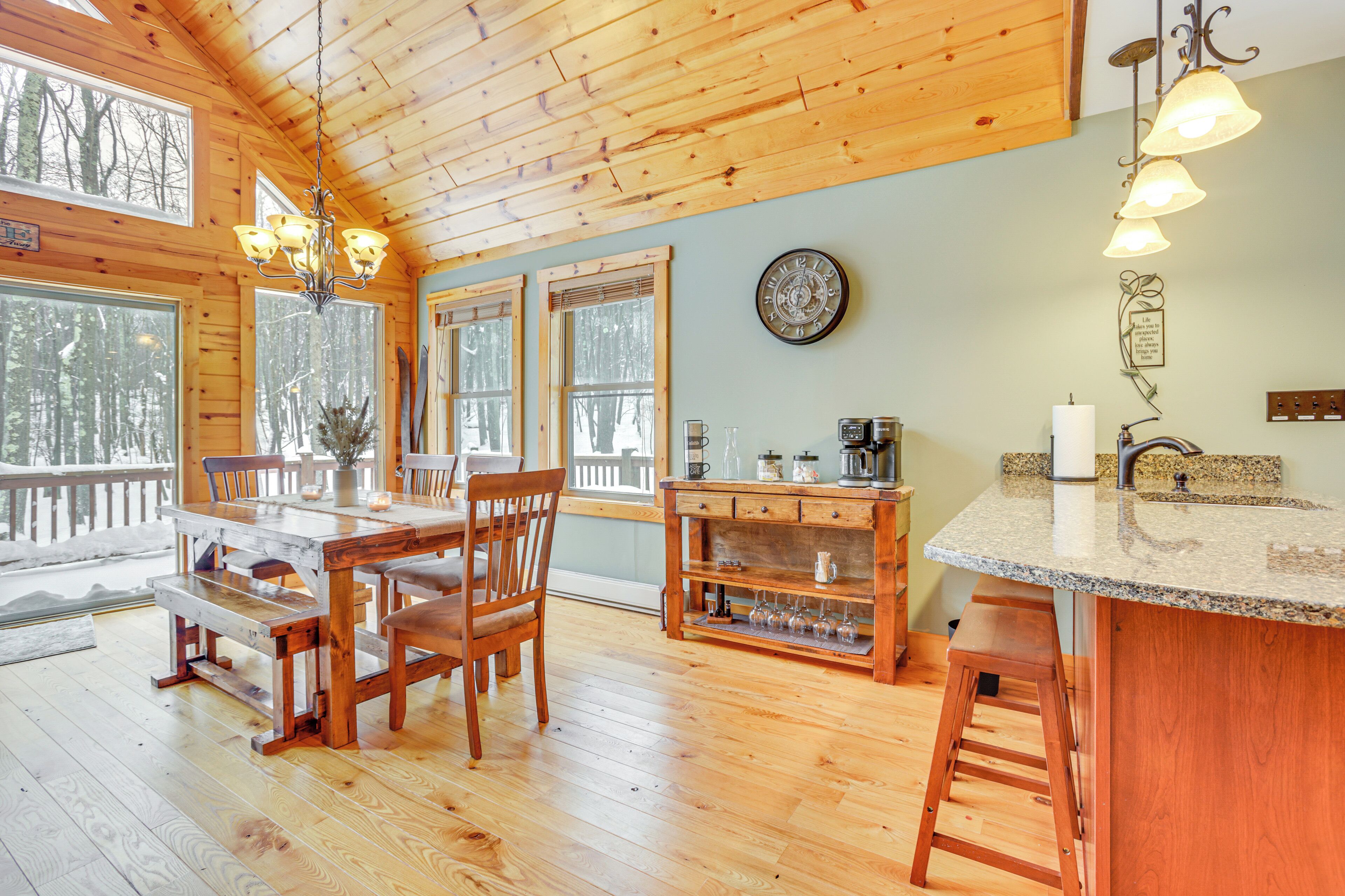 L’intérieur d’une cabane en bois comprend un coin repas, une cuisine et de grandes fenêtres.